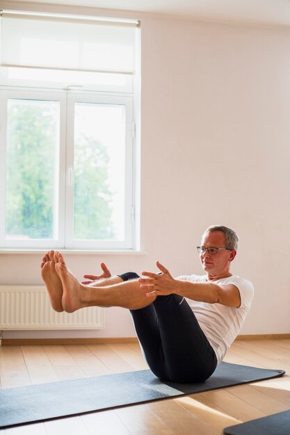 Senior man doing exercises at the gym