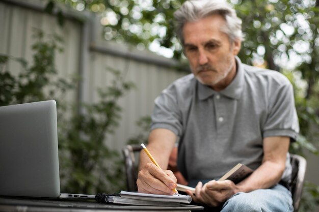 Senior man doing online classes on a laptop