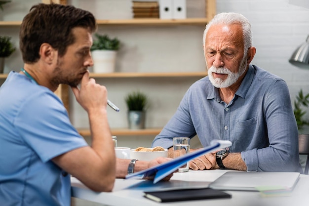 Free photo senior man feeling worried while analzying his medical reports with a doctor during medical appointment