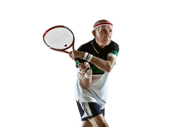 Free photo senior man playing tennis in sportwear isolated on white wall