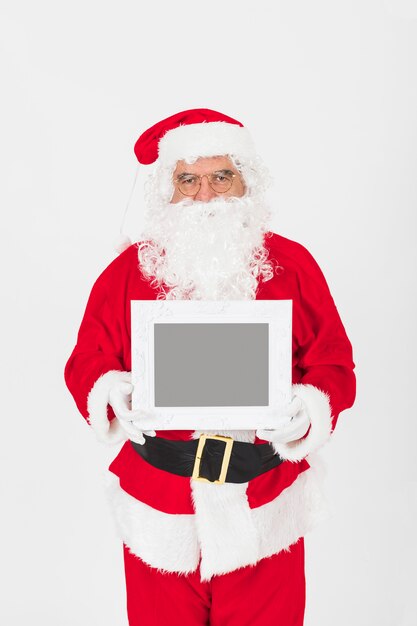 Senior man in Santa Claus costume holding empty frame 