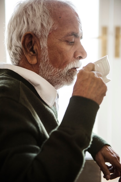 Free Photo senior man sipping and drinking tea