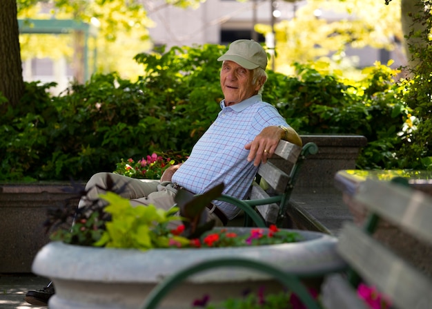 Free photo senior man sitting on a bench outdoors