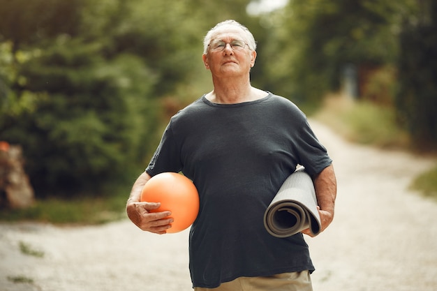 Free photo senior man at summer park. grangfather using a ball.