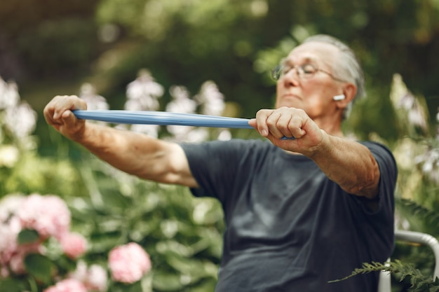 Free photo senior man at summer park. grangfather using a eraiser.