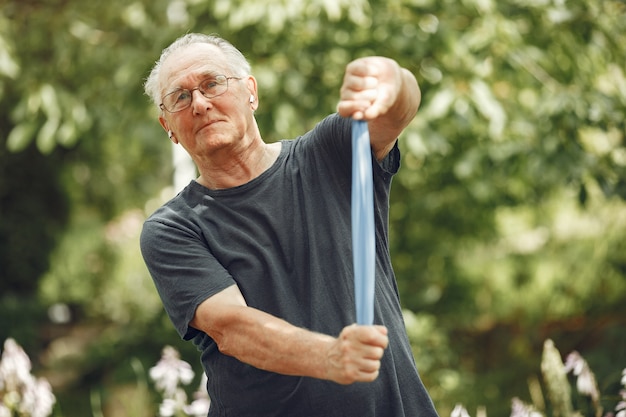 Free photo senior man at summer park. grangfather using a eraiser.