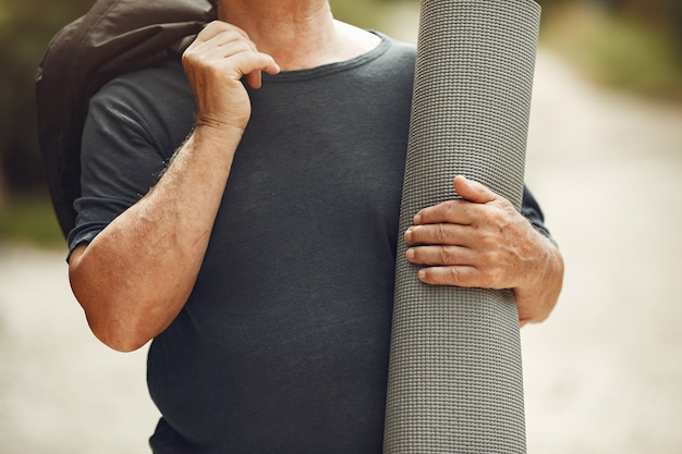 Free photo senior man at summer park. grangfather with a mat.