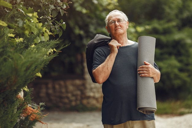 Free photo senior man at summer park. grangfather with a mat.