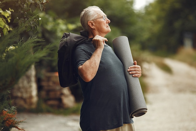 Free Photo senior man at summer park. grangfather with a mat.