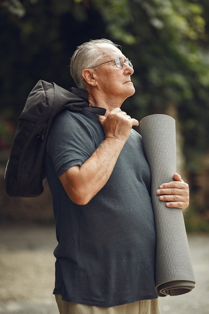 Free photo senior man at summer park. grangfather with a mat.