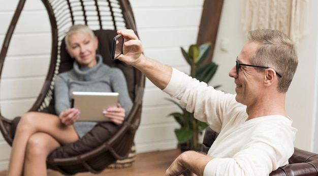 Free photo senior man taking a selfie next to his wife