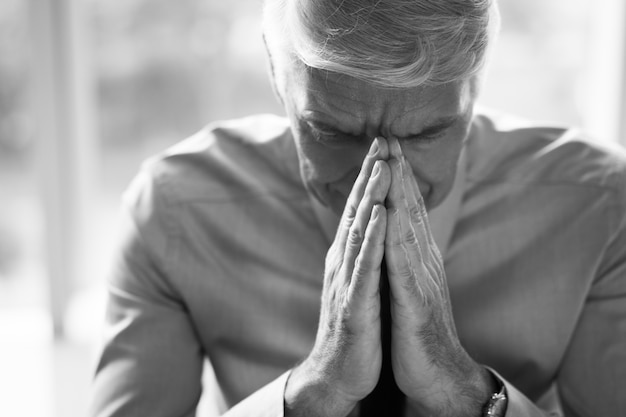 Free photo senior man thinking deep with hands together