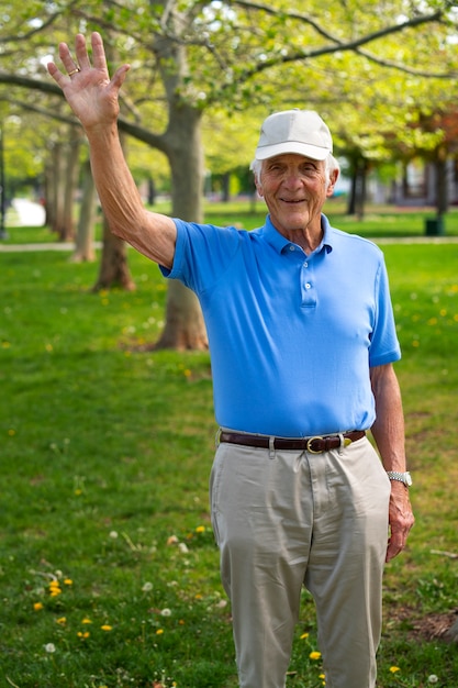 Senior man waving while taking a walk outdoors