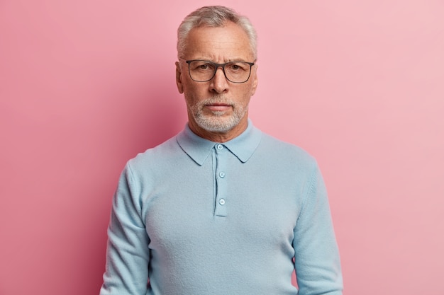 Senior man wearing blue shirt and trendy eyeglasses