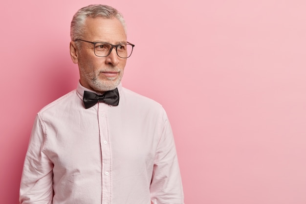 Free Photo senior man wearing white shirt and black bowtie