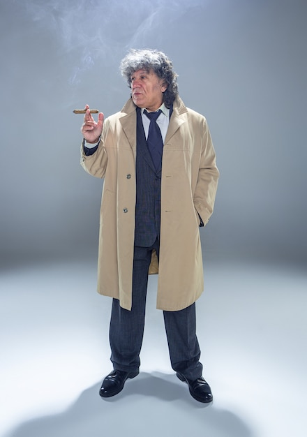 Free photo the senior man with cigar as detective or boss of mafia