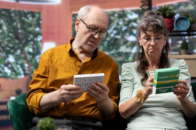 Free Photo senior man and woman reading labels on medicine pills boxes treatment