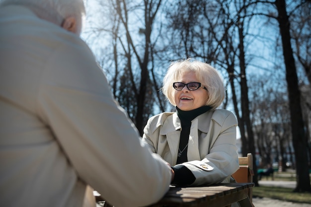 Senior people holding hands side view