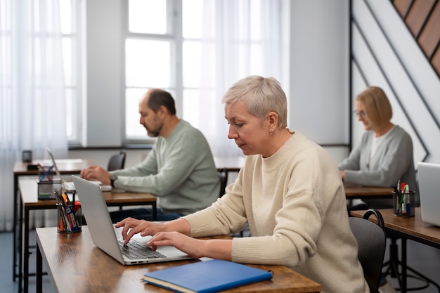 Senior people in school during class with laptop computer