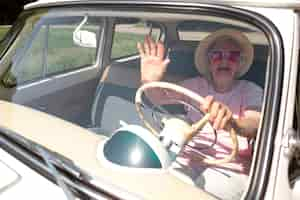 Free photo senior traveler wearing red sunglasses in her car