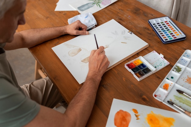 Free Photo senior watercolorist in the studio painting with watercolor