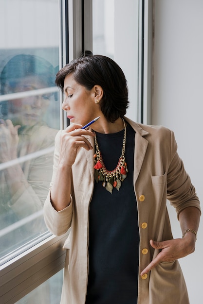 Free Photo senior with necklace looking away medium shot