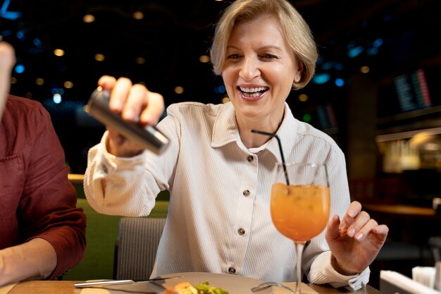 Senior woman adding salt on her food at a restaurant