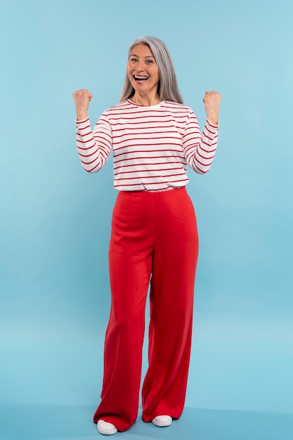 Free photo senior woman being excited against a blue background