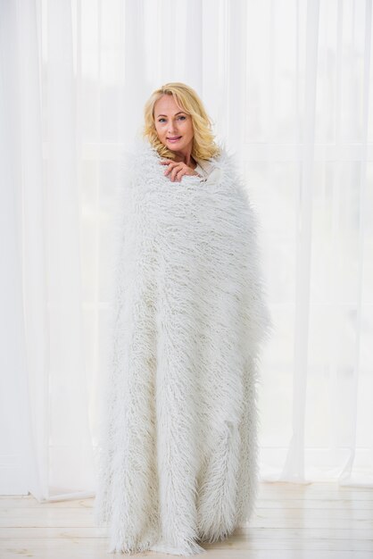 Senior woman covering herself with a fluffy blanket 