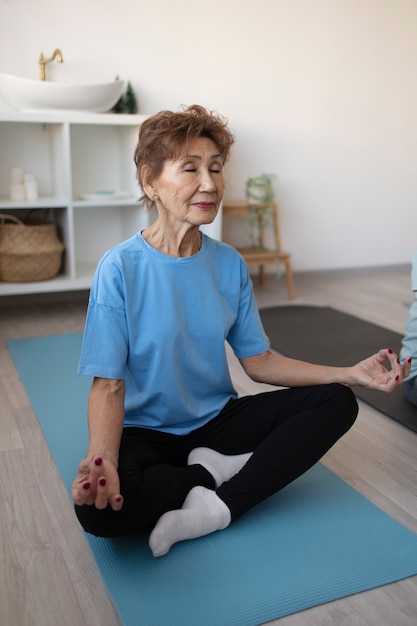 Senior woman doing yoga at home