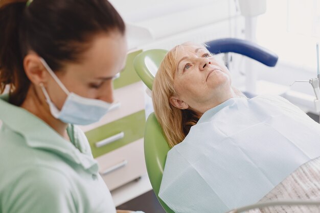 Senior woman having dental treatment at dentist's office. Woman is being treated for teeth