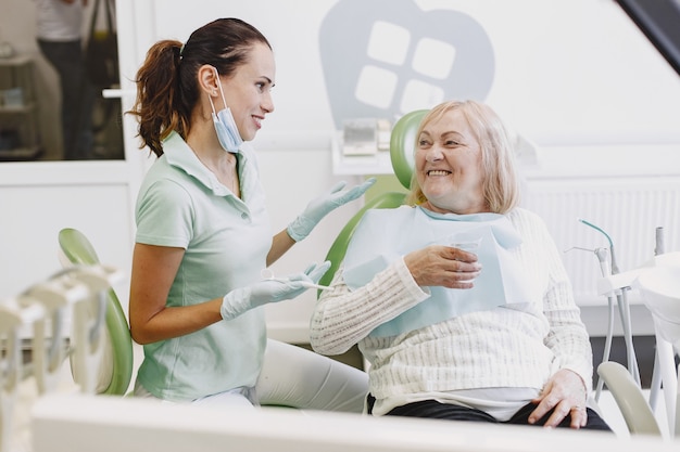 Free photo senior woman having dental treatment at dentist's office. woman is being treated for teeth