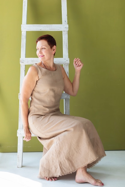 Senior woman on a ladder looking away