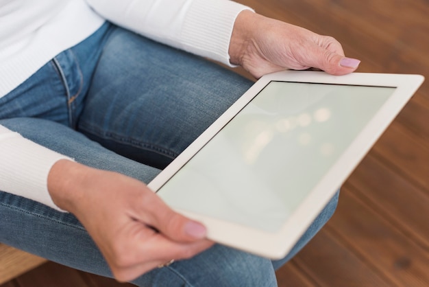 Senior woman looking on her tablet indoors