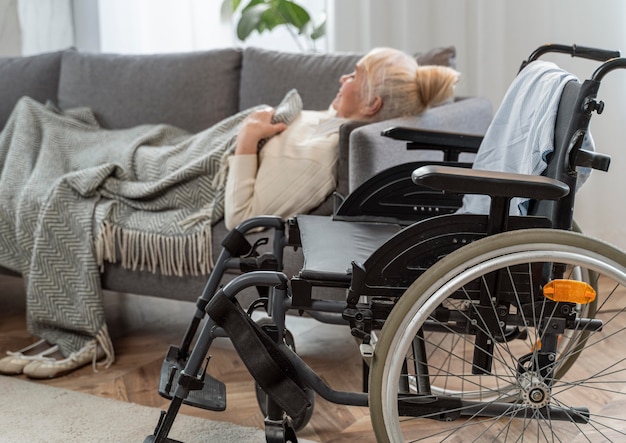 Senior woman lying in bed next to a wheelchair