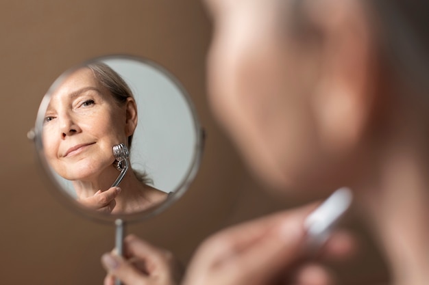 Senior woman massaging face side view