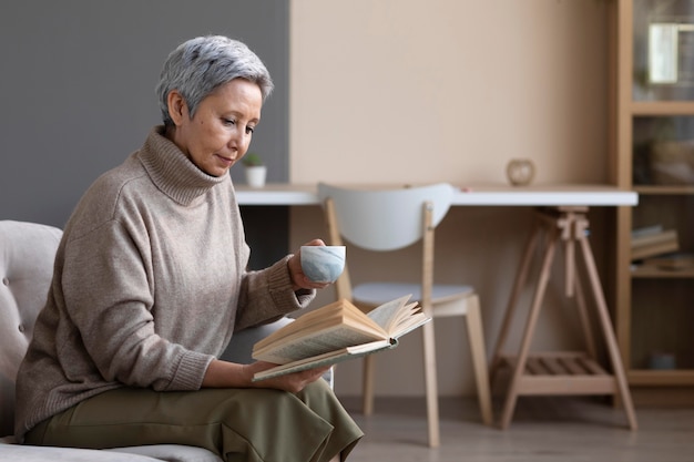 Free photo senior woman reading a book at home