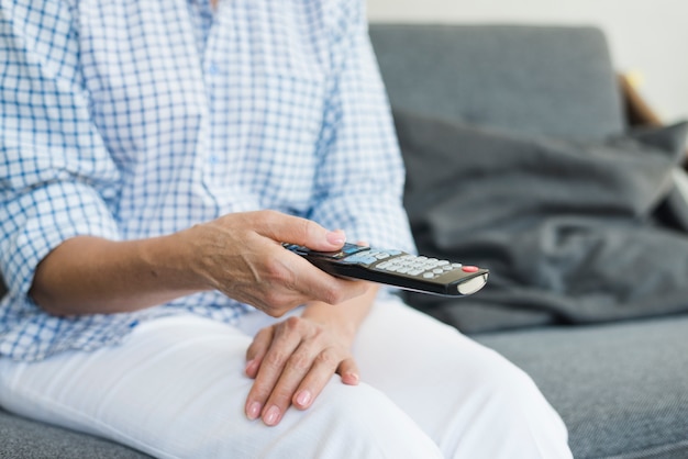 Senior woman's hand holding remote control