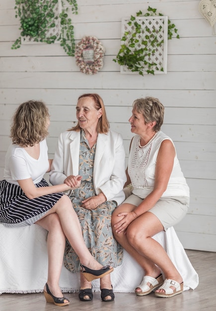 Senior woman sitting on sofa with her daughter and grand daughter at home