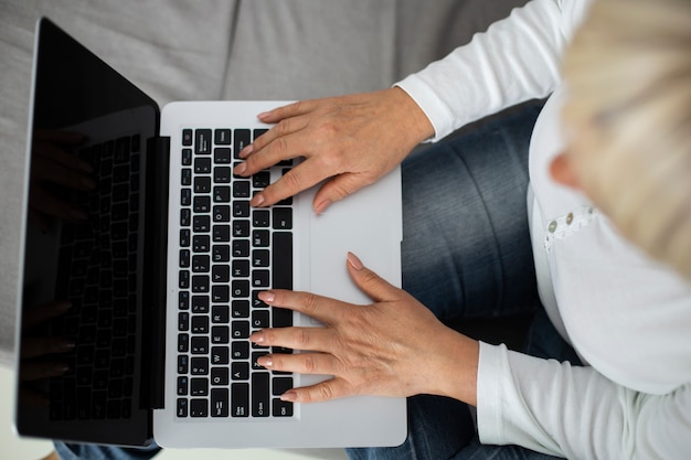 Free photo senior woman taking an online class on her laptop at home