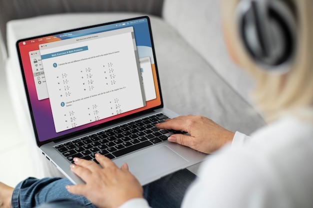 Senior woman taking an online class on her laptop at home