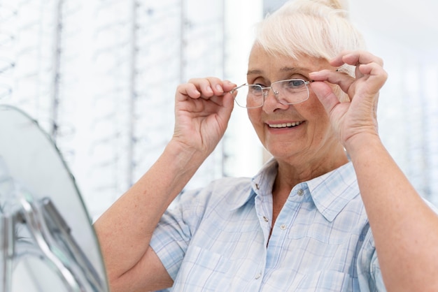 Free Photo senior woman trying on a new pair of glasses