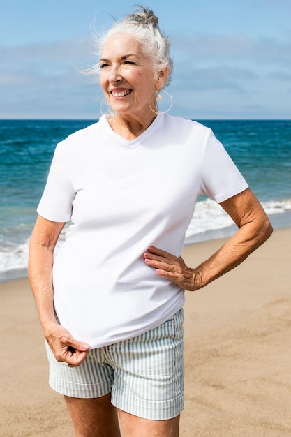 Free photo senior woman in white tee at the beach