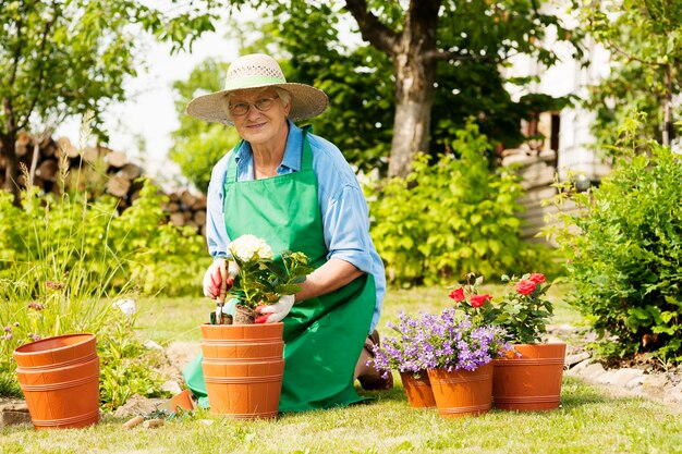 Senior woman with flowers in garden