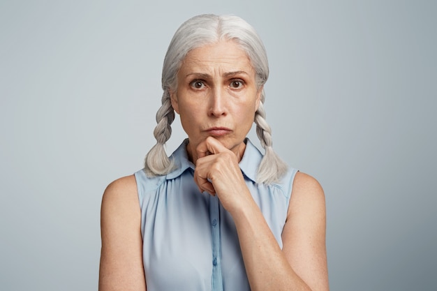 Senior woman with pigtails dressed in blue blouse