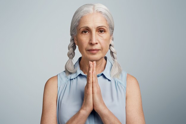 Senior woman with pigtails dressed in blue blouse