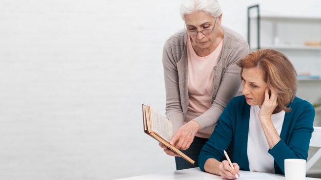 Senior women looking into a book