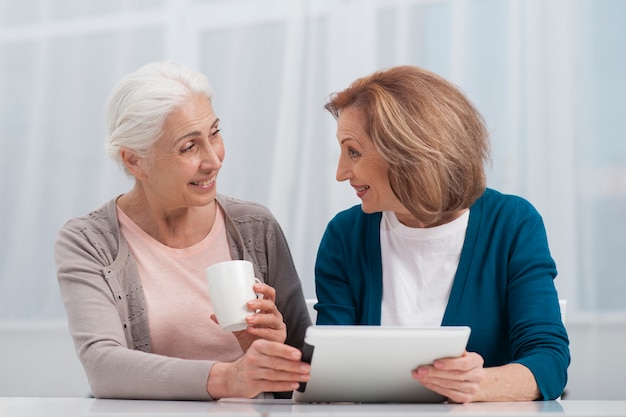 Senior women smiling at each other