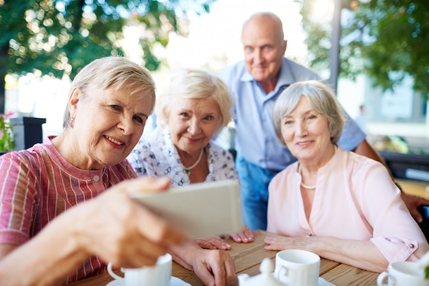 Seniors taking selfie with smartphone