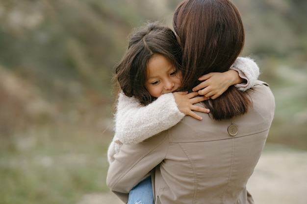 Sensual photo. Cute little girl. People walks outside. Woman in a brown coat.